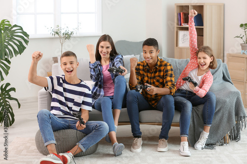 Teenagers playing video games at home