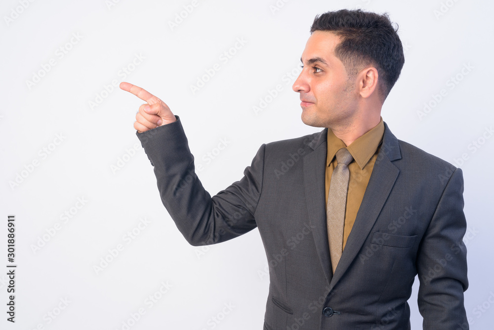 Profile view of handsome Persian businessman in suit pointing finger Profile view of handsome Persian businessman in suit pointing finger