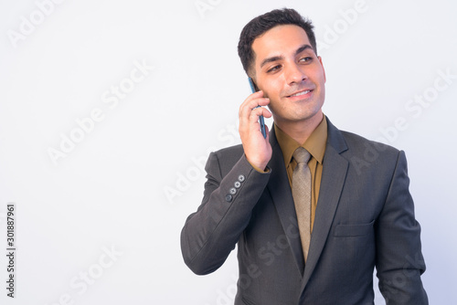 Portrait of happy Persian businessman talking on the phone