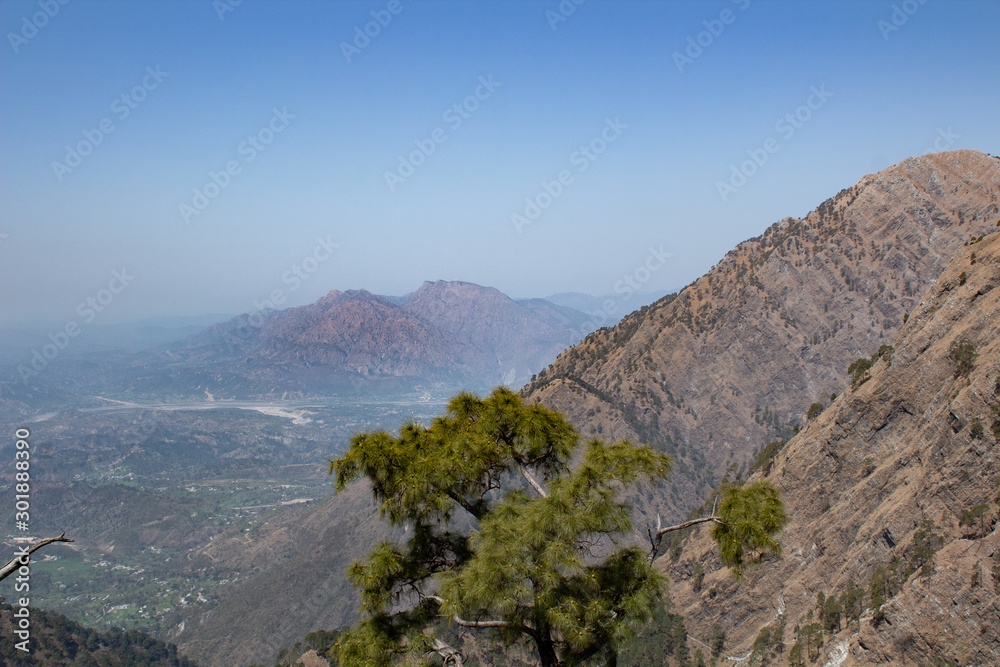Wide shot of beautiful mountain ranges with two red peaks in the far away background. Geography Concept