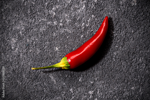 Top view of red fresh little chili peppers on black stone background. the concept of penis the potency, libido, stallion, drugs for potency