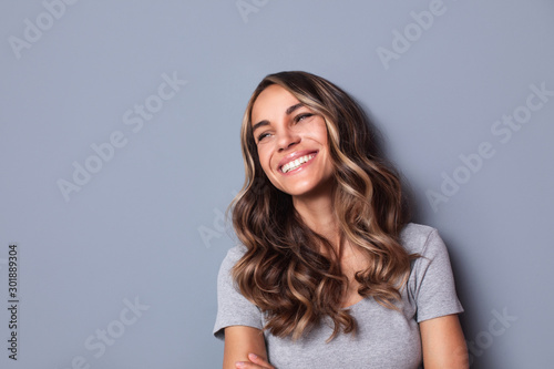 Beautiful smiling woman studio shot on gray background. photo