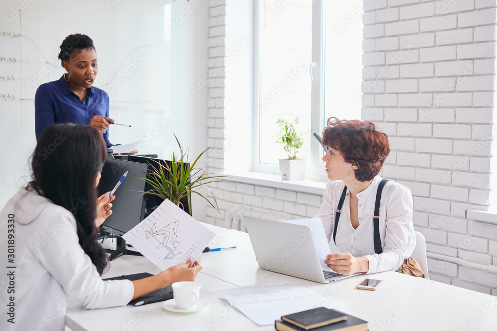 Obraz premium Business for people concept. Effective business meeting, successful team of international business team in office, talking, explaining. Attentive listeners listen to african coach in blue wearing