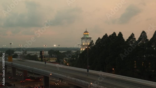 Slow Zoom in to Majlis Bandaraya Johor Bahru Clocktower in Malaysia in the evening. Cars travelling on highway. photo