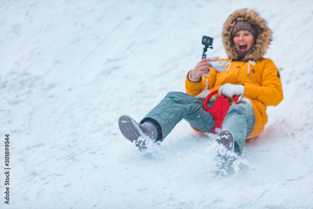 young woman sliding down by snowed hill young woman sliding down by snowed hill