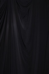 Black Curtain drape wave with studio lighting, Wallpaper Background Texture Detail of light and shadow, stage opening screen for performance and music