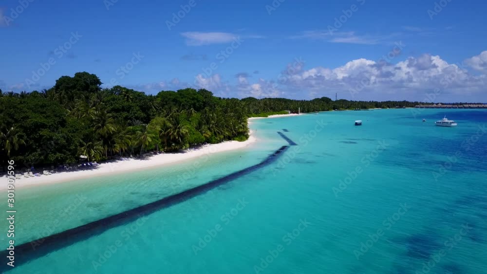 Drone pull back on a tropical island with palm trees and turquoise shallow waters in Seychelles, Indian Ocean