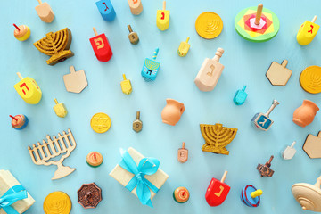 religion image of jewish holiday Hanukkah background with menorah (traditional candelabra), spinning top over wooden blue background. top view, flat lay