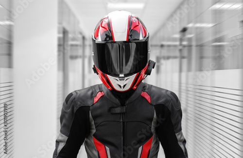 A man in a helmet and full motorcycle gear. In offices