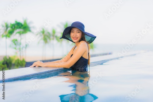 Portrait beautiful young asian women happy smile relax outdoor swimming pool in hotel