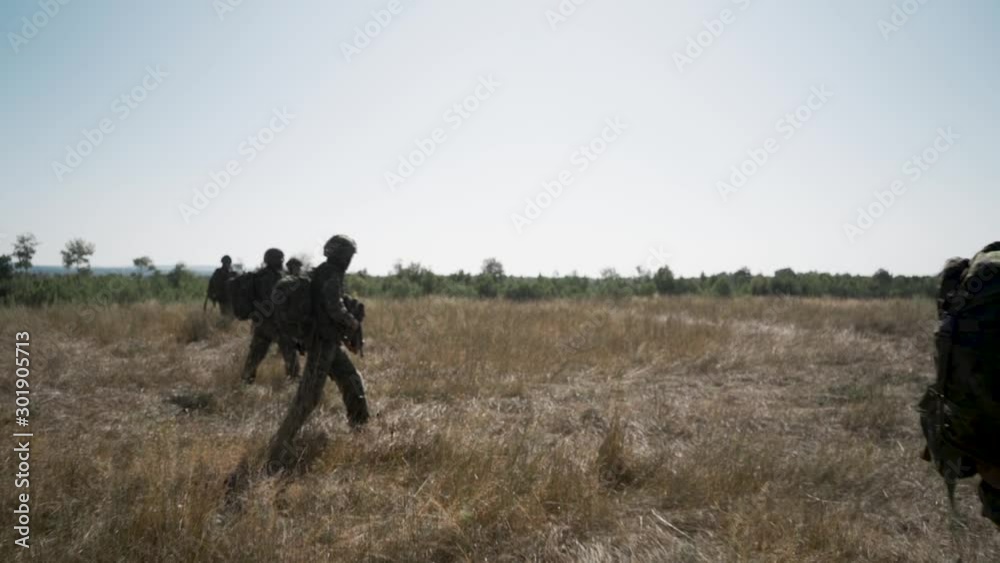 Soldiers walking across a field Soldiers walking across a field