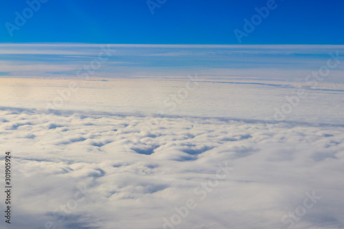 Beautiful white clouds in blue sky. View from airplane