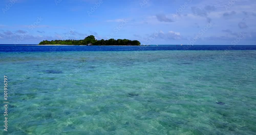 Drone flying towards a remote island with a luxury resort on it in Maldives Drone flying towards a remote island with a luxury resort on it in Maldives