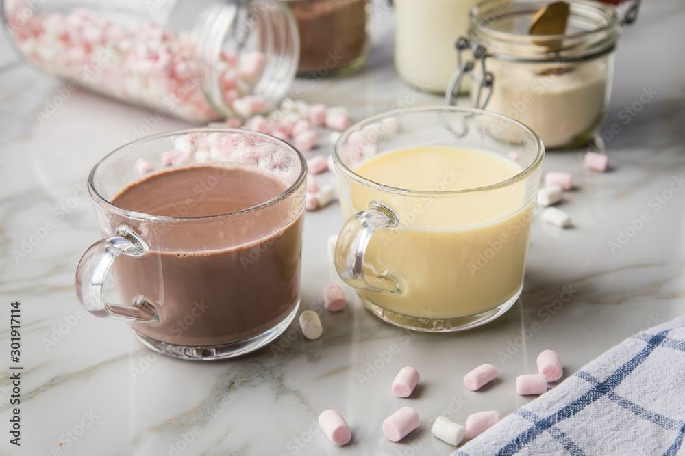 Zubereitung von heißer, dunkle und weiße Trinkschokolade mit Milch, Kakaopulver und Marshmellows auf Marmor hell Hintergrund Zubereitung von heißer, dunkle und weiße Trinkschokolade mit Milch, Kakaopulver und Marshmellows auf Marmor hell Hintergrund