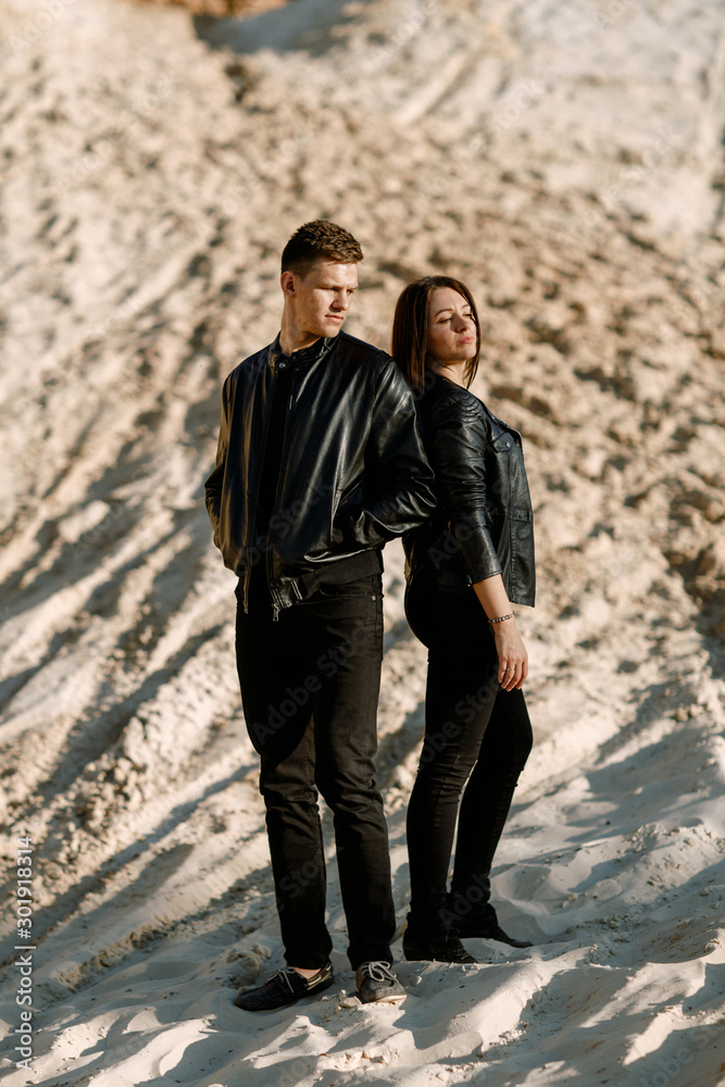 Beautiful couple in black clothes alone on the background of the Songbook Beautiful couple in black clothes alone on the background of the Songbook