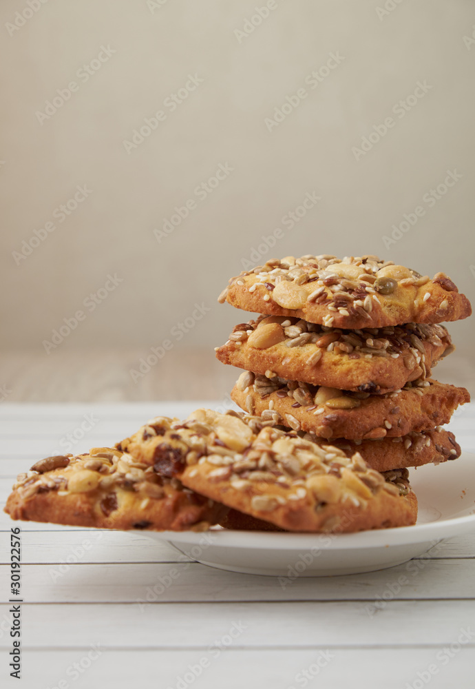 oat cookies chips and ingredients banana walnuts almonds raisin dried apricots on wooden table soft focus close up