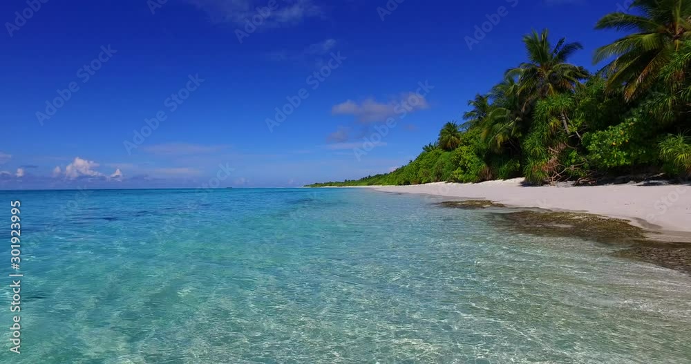 Bright colors of tropical seascape with palm trees over white sandy beach washed by crystal emerald lagoon under clear blue sky in Philippines