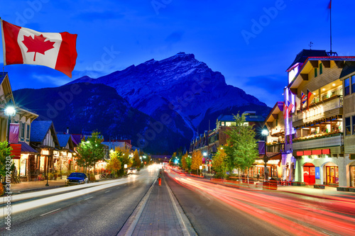 Schilderij op canvas Canadian flag with Banff Avenue at twilight time, Alberta, Canada
