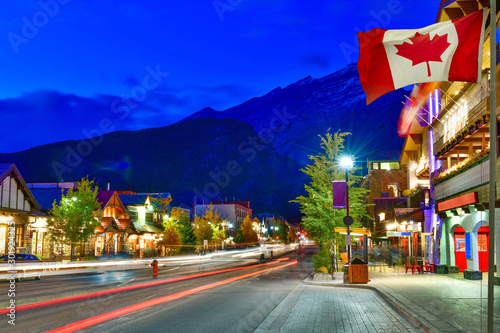 Canadian flag with Banff Avenue at twilight time, Alberta, Canada