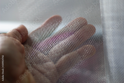 The mechanic is cutting the net to build a mosquito net.
