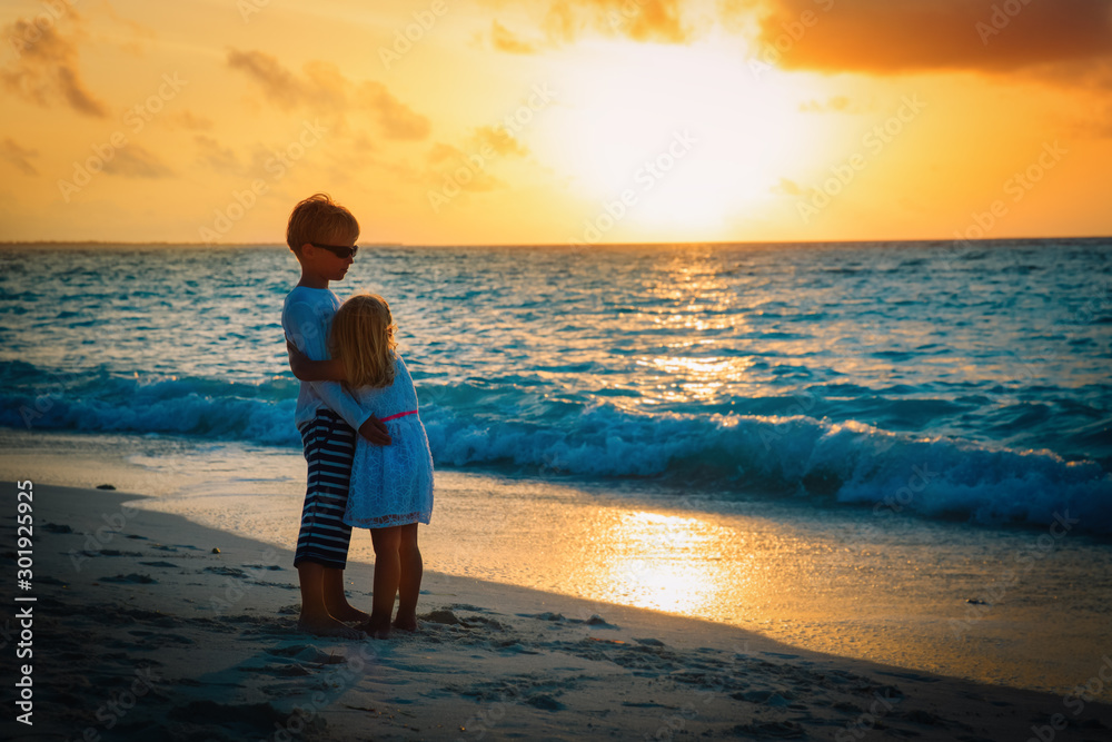 happy little boy and girl hug at sunset beach