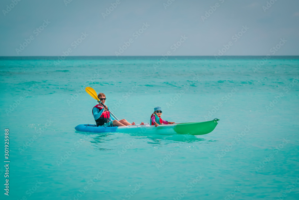father and little daughter kayaking on beach