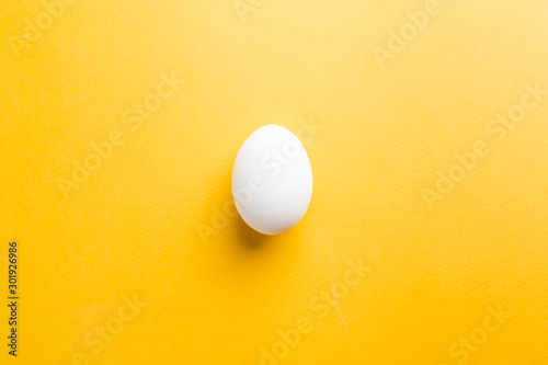White egg on the yellow background in center. Pop art design minimalism style