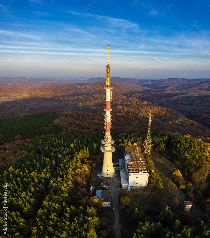Tv tower on hill and autumn forest at sunset