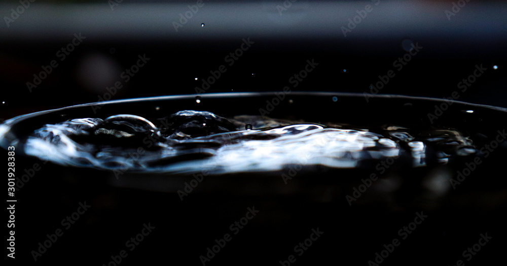 The movement of water in a bowl close-up on a dark background.