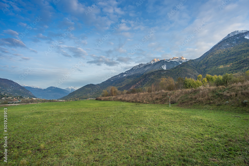 Countryside landscape with mountains in the background at blue hour.