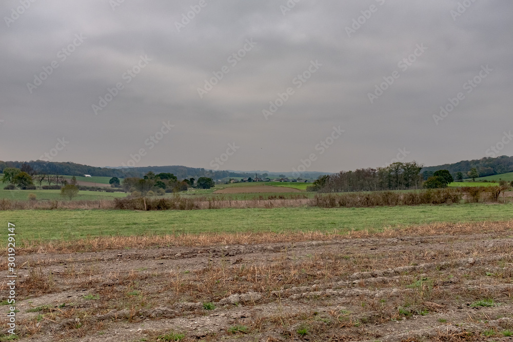 Plowed pasture in the Ardennes with a village in the background