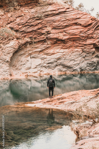 Young man traveler by the lake of Hamersley Gorge