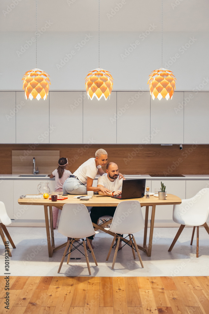 Caucasian couple at home. Man work looking at laptop. Tired husband, wife try to relax him. Family, love concept Caucasian couple at home. Man work looking at laptop. Tired husband, wife try to relax him. Family, love concept