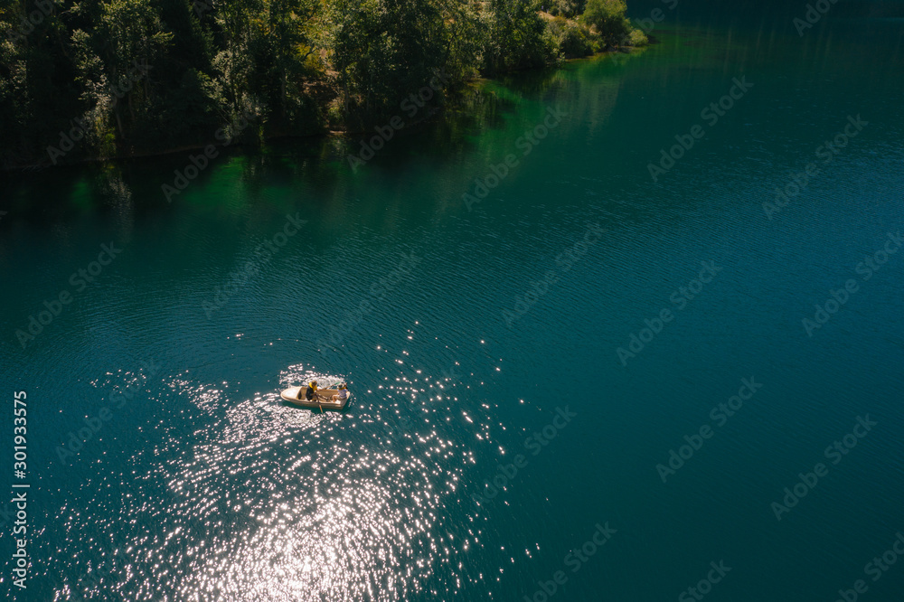 Fototapeta premium Boat on beautiful blue mountain lake, aerial view, tranquil landscape. Kolsay, Kazakstan