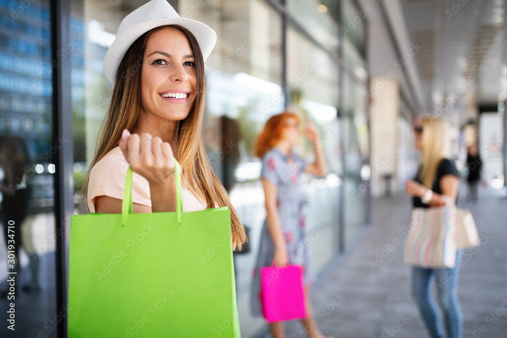 Women friends with shopping bags having fun while shopping in a mall Women friends with shopping bags having fun while shopping in a mall