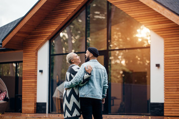 Rear view on lovely couple looking at new countryhouse. Excited man and woman, smile and happy together