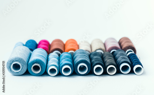 Colored sewing thread coils on white background with copy space for text. photo