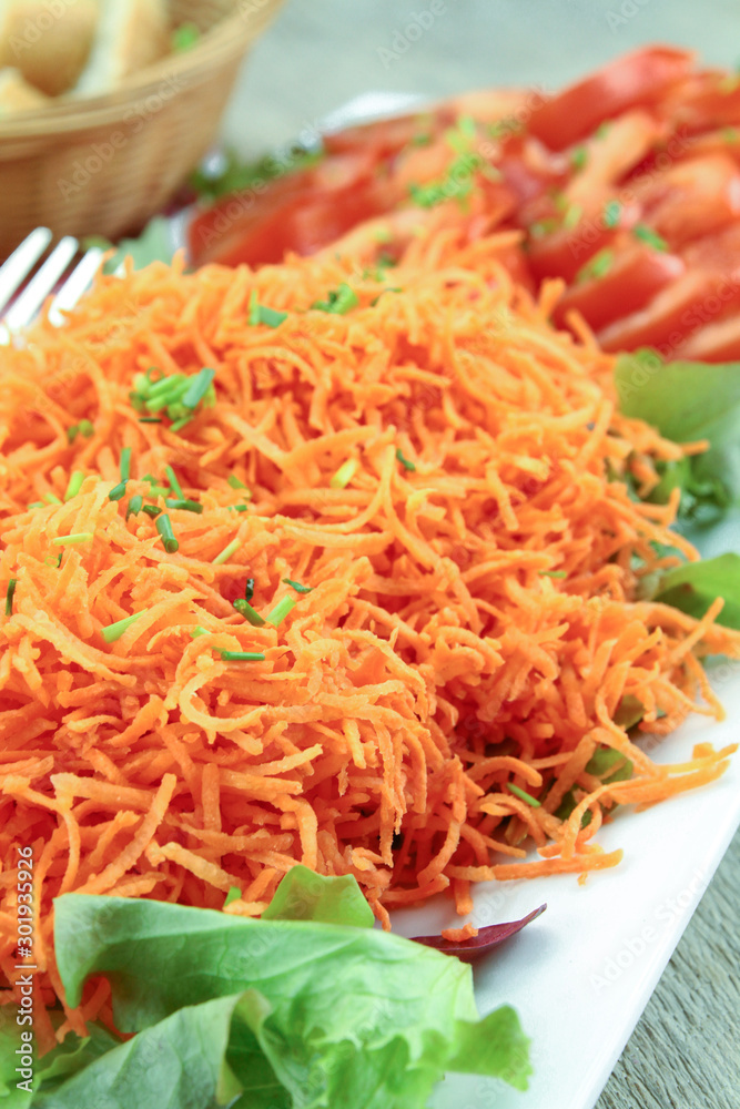 dish of grated carrots and slices of tomatoes dish of grated carrots and slices of tomatoes