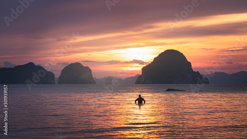 Bilde på lerret A man standing on beach confront to beautiful sunset and dramatic sky in Krabi T