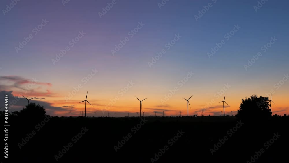 Scenic landscape of the wind turbine for electric power make against nature agriculture farm for renewable clean power from wind in twilight sunset time with dark and grain processed Scenic landscape of the wind turbine for electric power make against nature agriculture farm for renewable clean power from wind in twilight sunset time with dark and grain processed