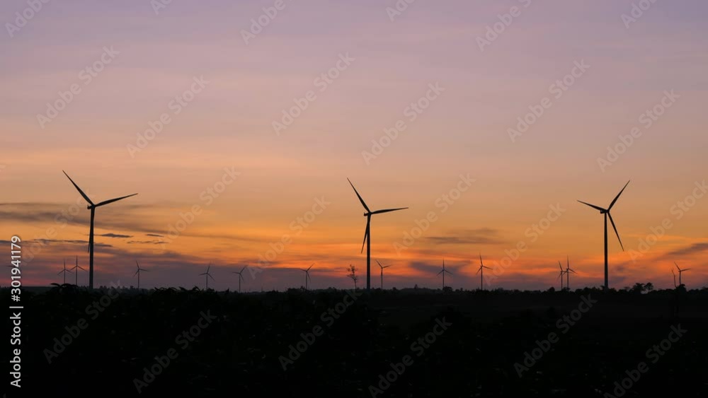 Scenic landscape of the wind turbine for electric power make against nature agriculture farm for renewable clean power from wind in twilight sunset time with dark and grain processed Scenic landscape of the wind turbine for electric power make against nature agriculture farm for renewable clean power from wind in twilight sunset time with dark and grain processed
