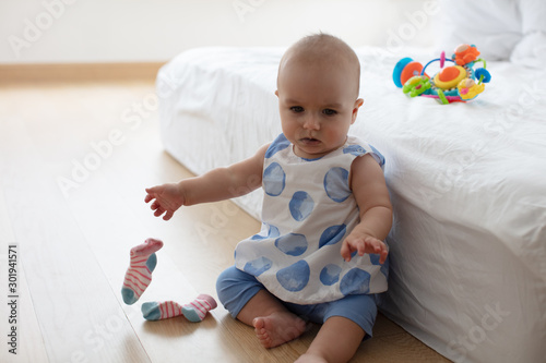 Baby girl throwing off her socks