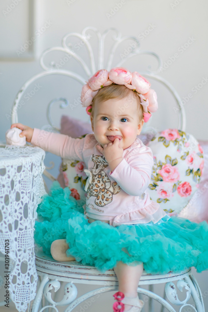 Fototapeta premium Image of sweet baby girl in a wreath, closeup portrait of cute 8 month-old smiling girl, toddler.