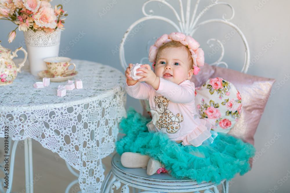 Fototapeta premium Image of sweet baby girl in a wreath, closeup portrait of cute 8 month-old smiling girl, toddler.