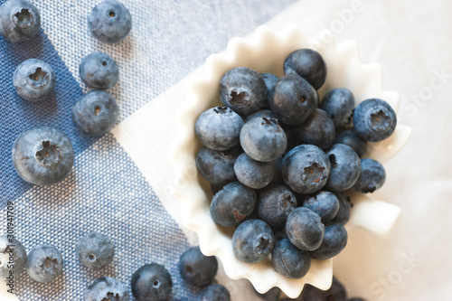 Blueberry closeup. Freshly picked blueberries in wooden bowl over rustic background. Juicy and fresh berries. Bilberries on wooden table. Diet, dieting. Healthy food concept. Vitamins and antioxidants