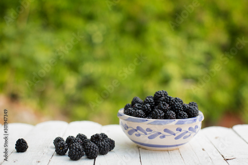 Still life with blackberries and figs on green leaves background