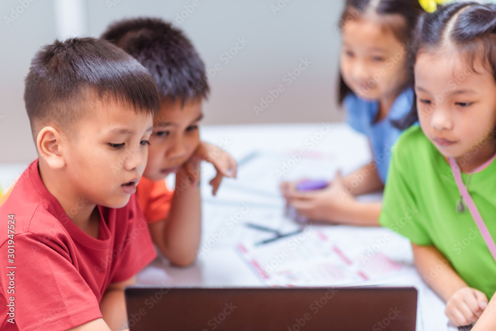 Asian elementary school children are studying lesson on laptop in the classroom. Asian elementary school children are studying lesson on laptop in the classroom.