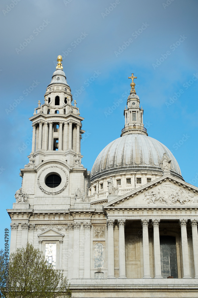 Scenic sunny view of the West Front facade of St Paul's Cathedral with baroque north bell tower in London, UK under blue spring sky