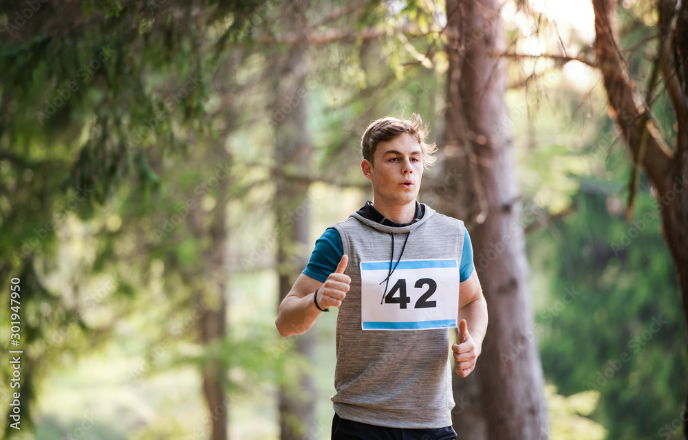 Front view of young man running a race competition in nature. Front view of young man running a race competition in nature.
