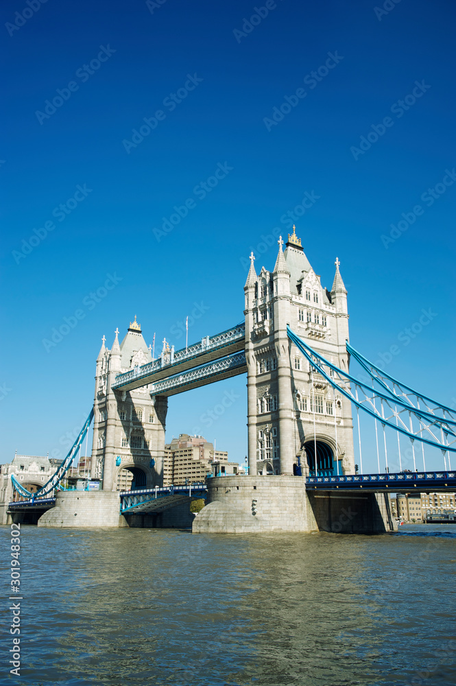 Bright sunny daytime view of Tower Bridge with clear blue sky above the River Thames in London, UK